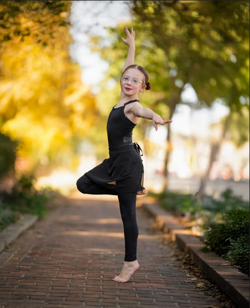 Mackenzie stands in a ballet dance pose.