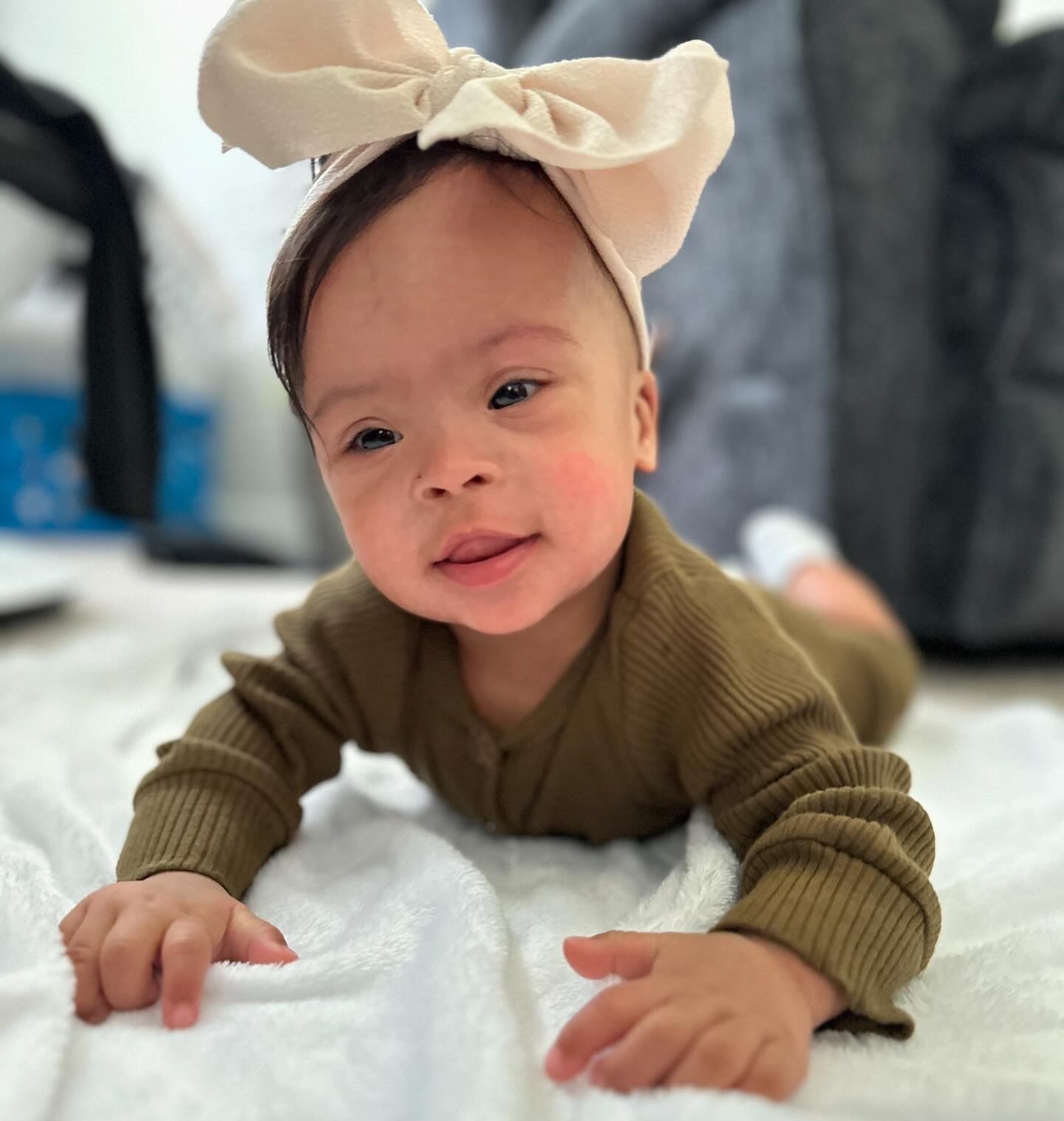 Raya smiling while wearing a bow in a her hair.