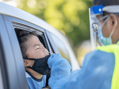 Medical professional taking nasal swab of child