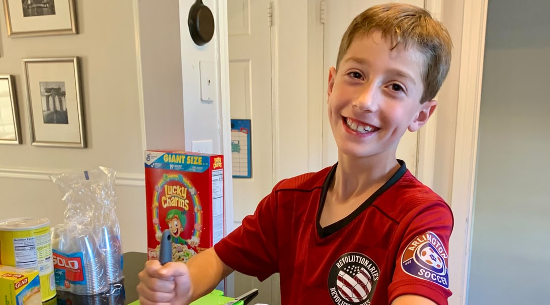 Owen smiling while making sticky marshmallow cereal bars.
