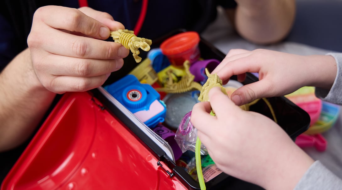Cleft and Craniofacial Program patient Henry picks a toy dinosaur from the treasure box.