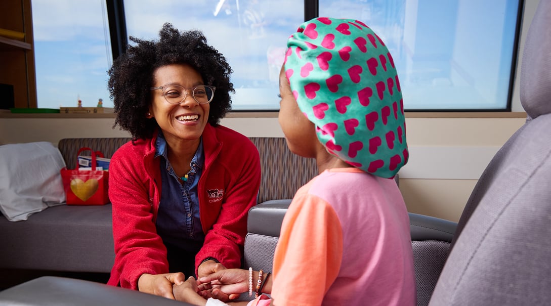 Doctor Risi Idiokitas shows Shakiya, a patient with sickle cell disease, acupressure points to help with headaches.