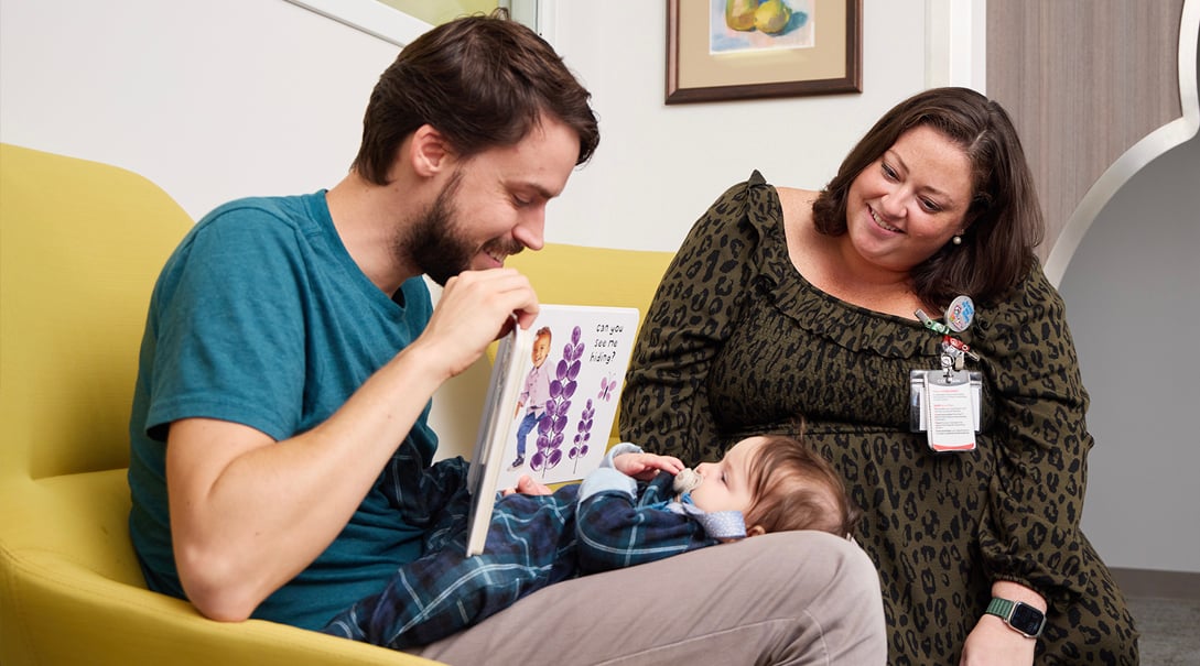 Allie Slocum and a patient family enjoy books from the library cart