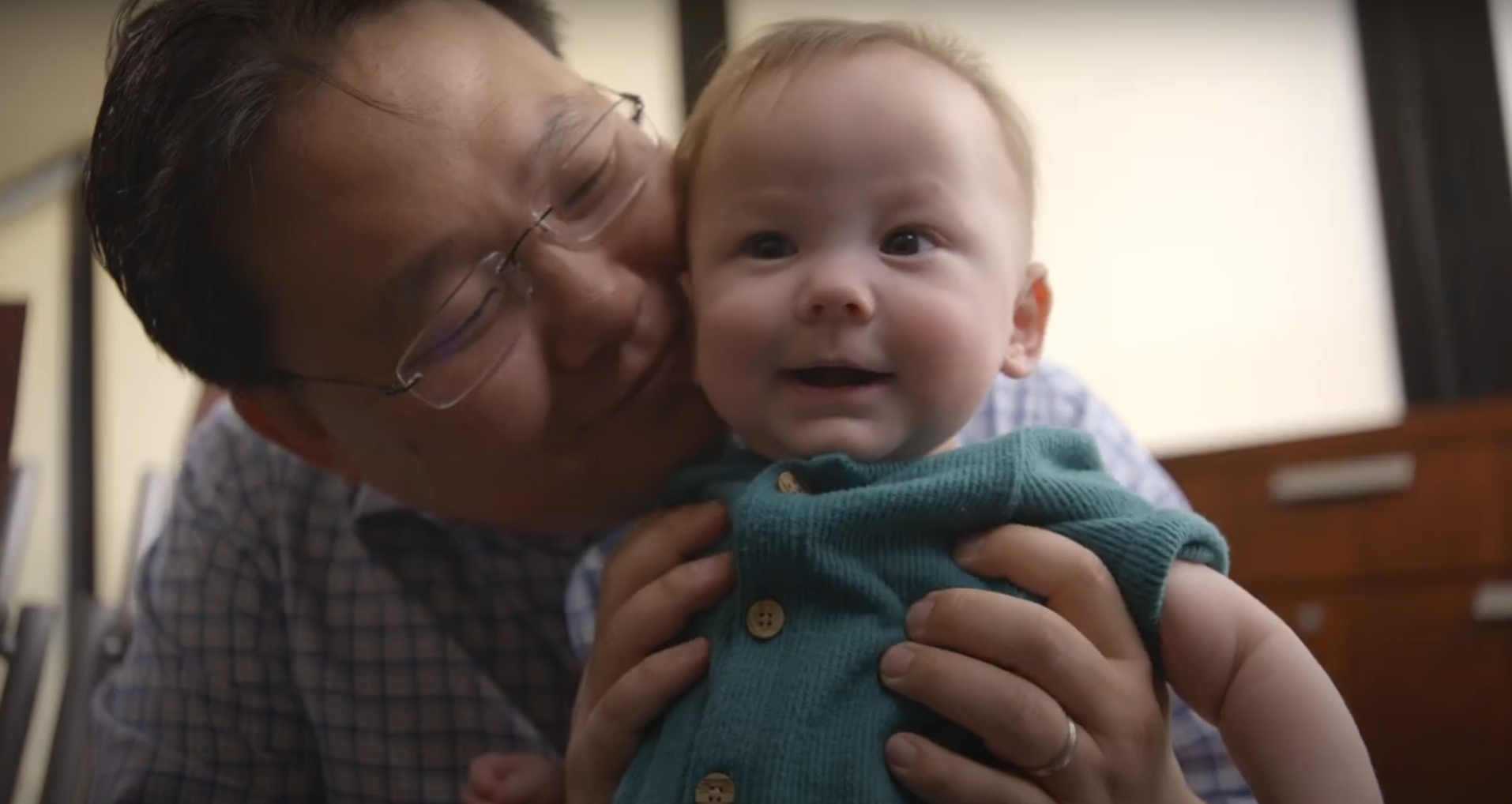 Infant Abby being held by her father