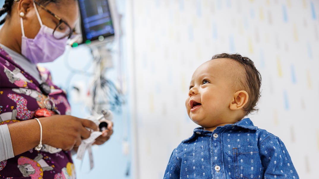 smiling baby with healthcare provider