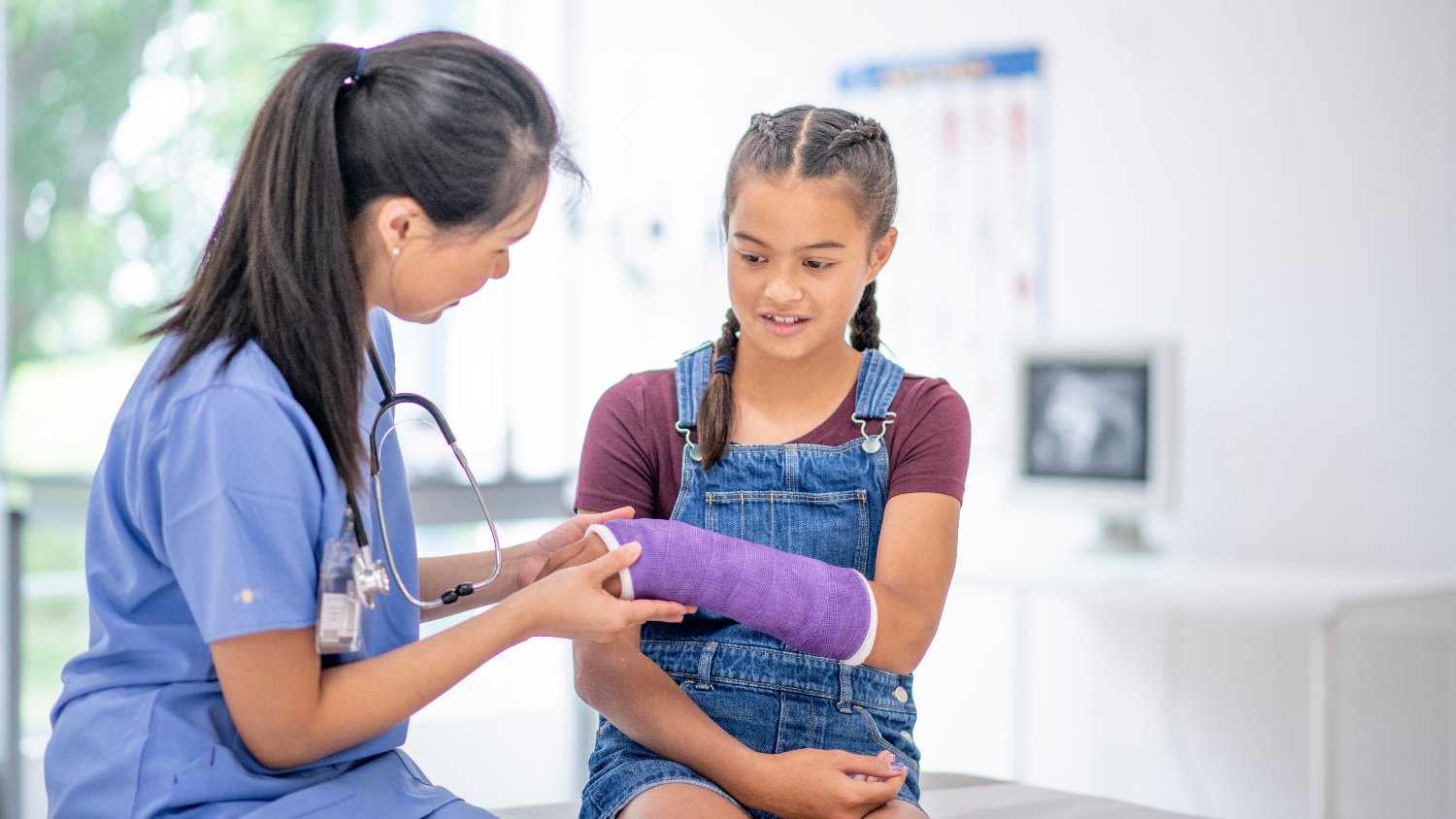 doctor checks child's arm cast