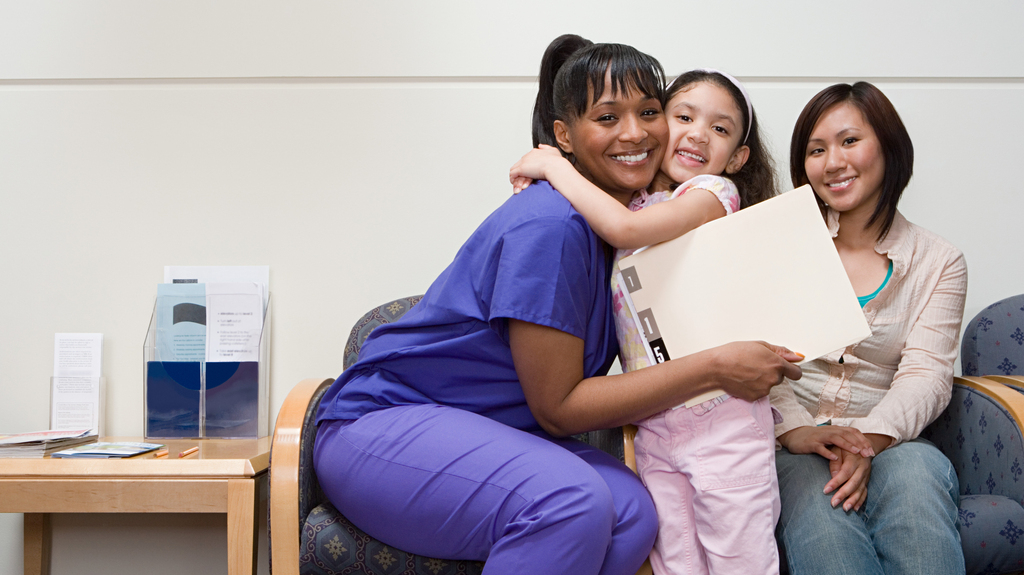 happy girl hugs hospital staff
