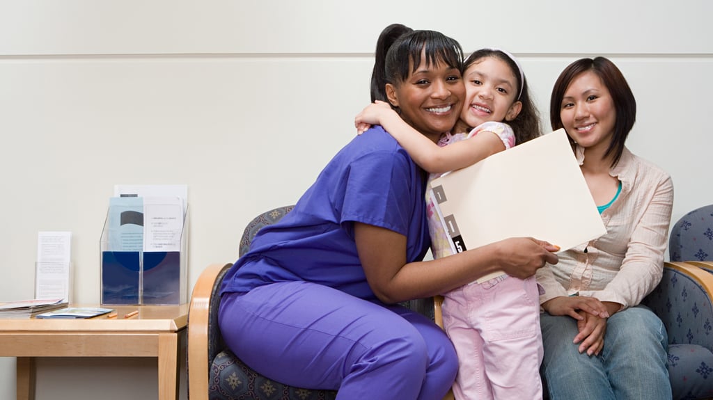 happy girl hugs hospital staff