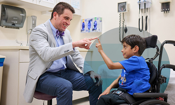 Provider with a patient seated in a wheelchair touch fingertips