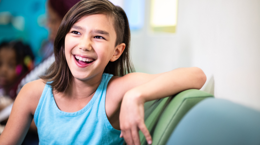 Young girl smiling while sitting on a couch