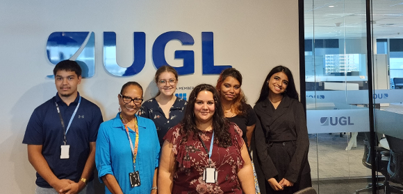 CareerTrackers students and UGL employees stand in front of UGL sign
