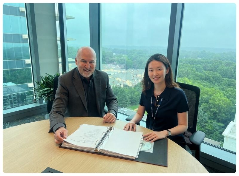 Étudiant en droit YutianYang assis dans un bureauavec son superviseur, le vice-président et conseiller juridique adjoint Steve Niparko.