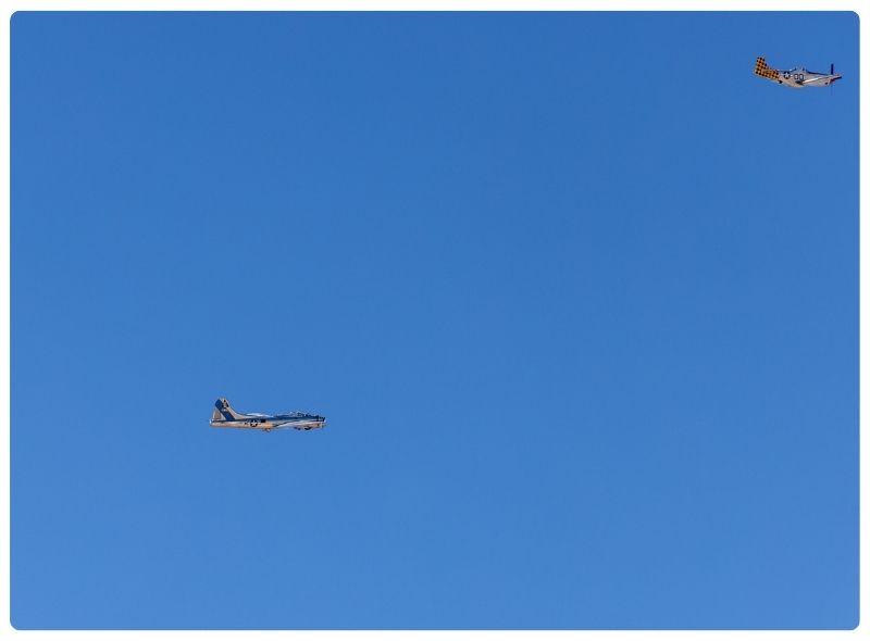 Two airplanes flying against a blue sky