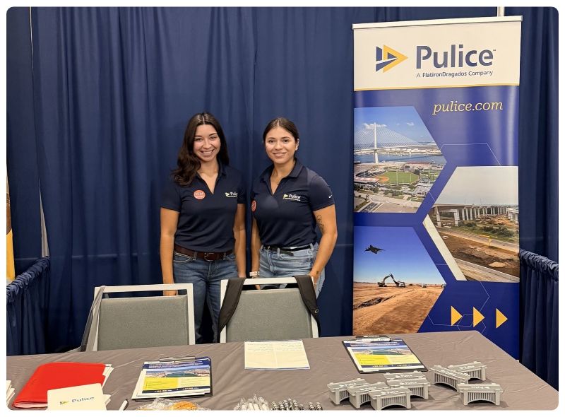 Two women stand behind a Pulice career fair booth