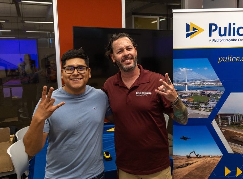 Two men standing at a construction career event
