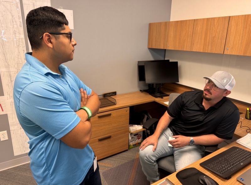 Two men speaking together in a construction office