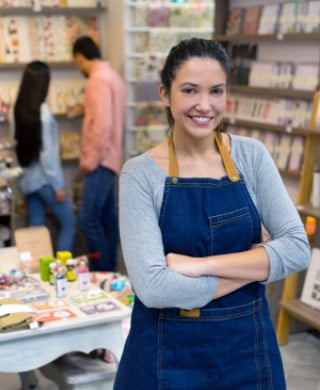 bookstore owner smiling and standing in store