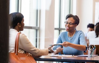 Two women sitting and speaking at a table