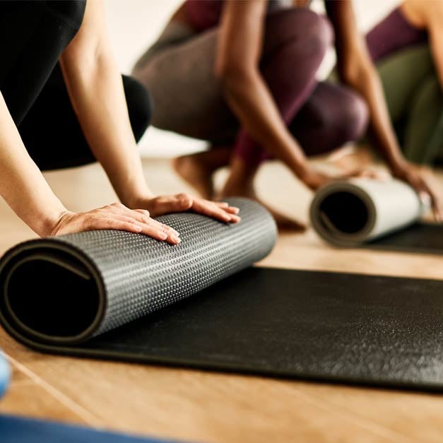 People rolling up exercise mat