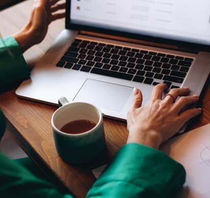 Woman with coffee working on her computer