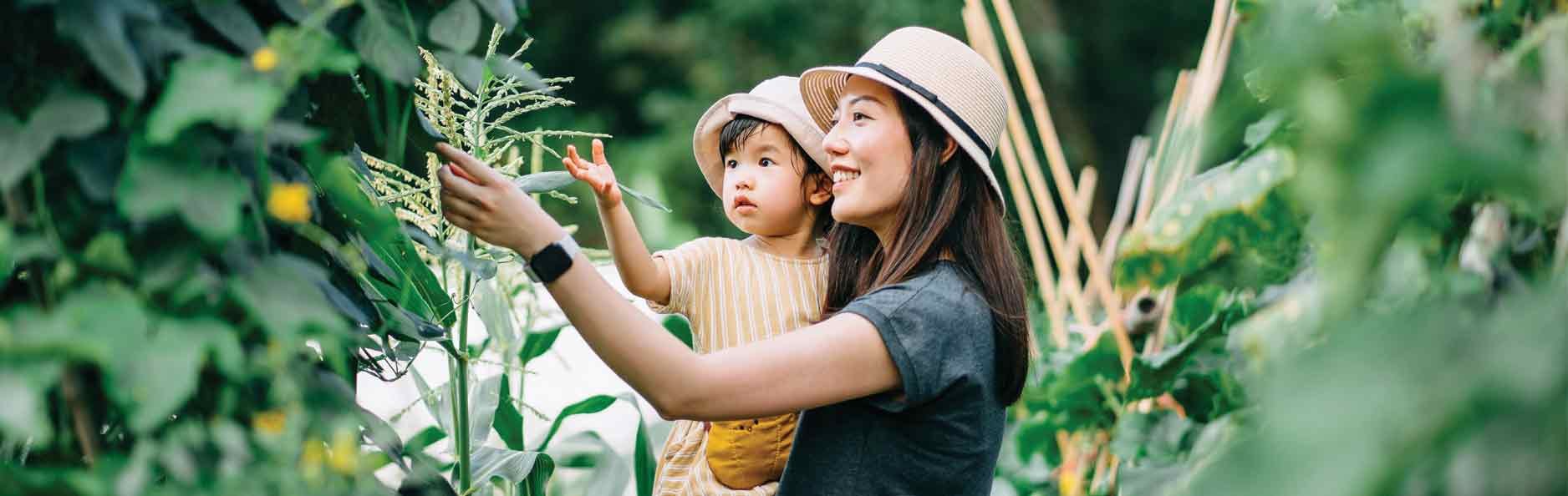 Mother and child exploring trees in a garden