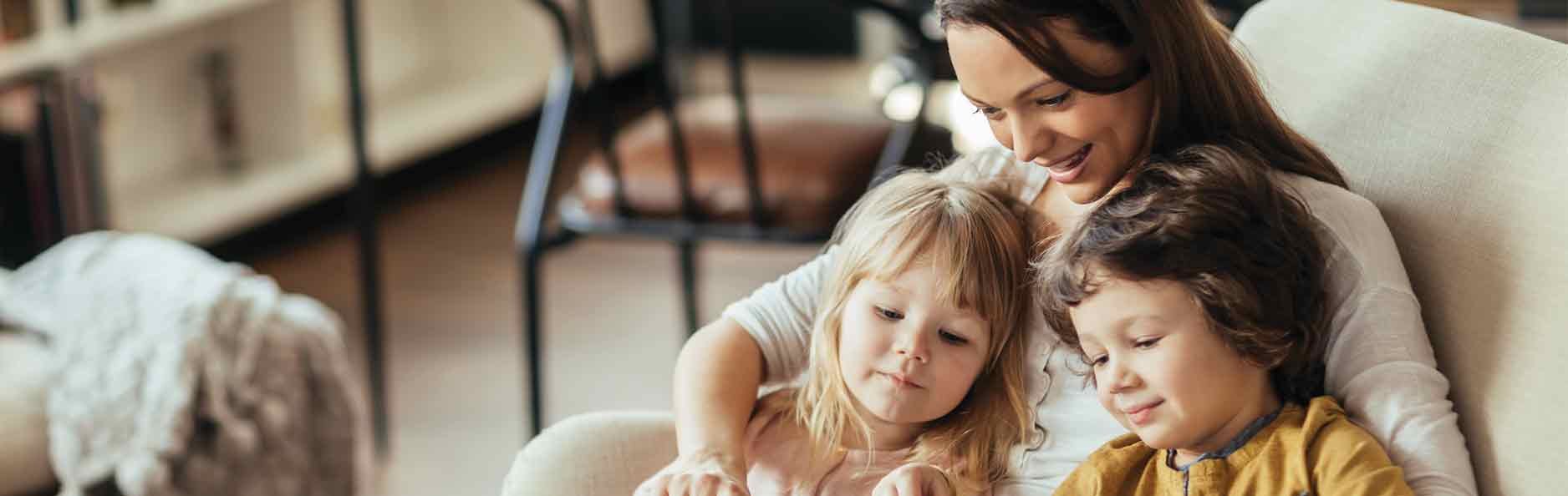 Mom and young children looking at a tablet at home