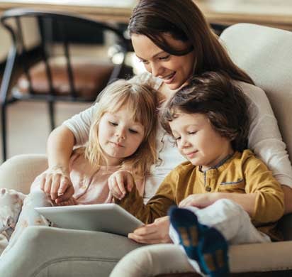 Mom and young children looking at a tablet at home
