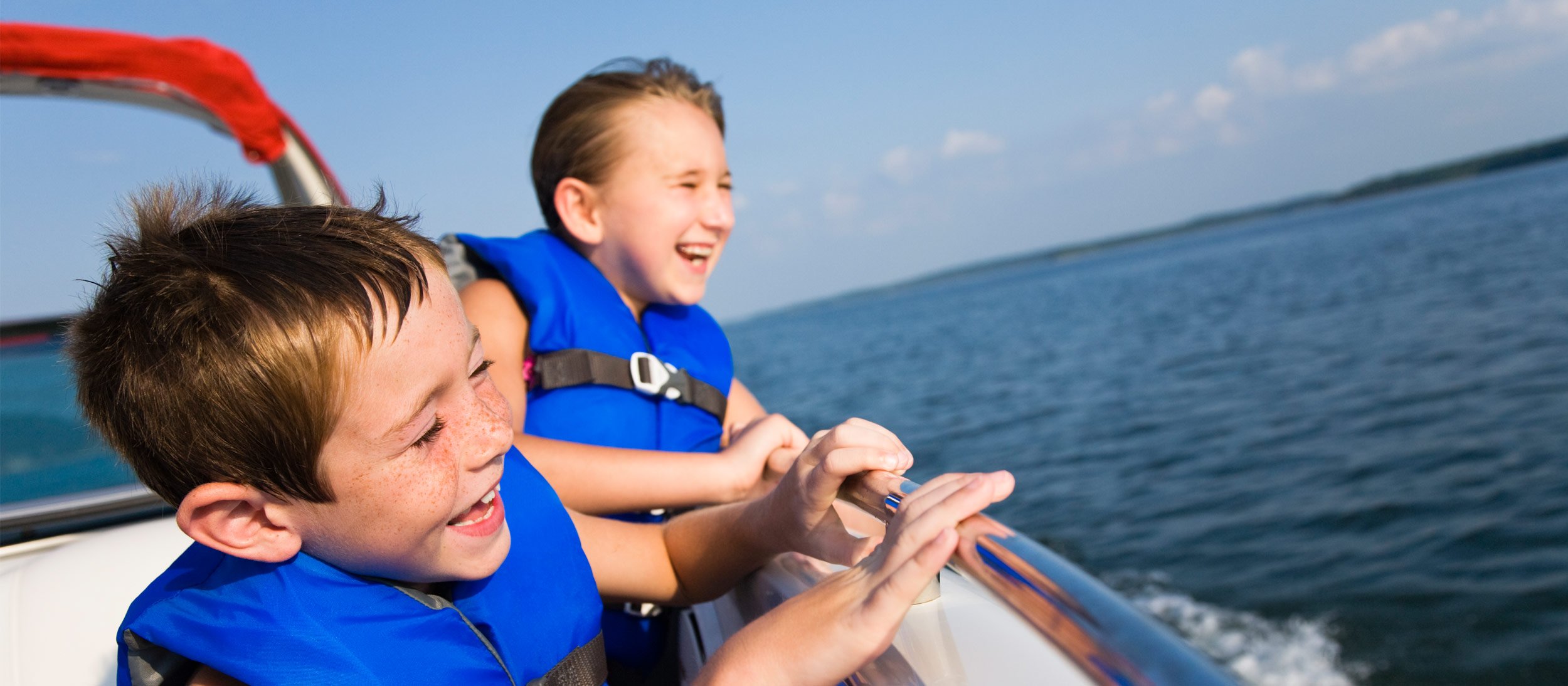 Two boys smiling while ridging in a boat