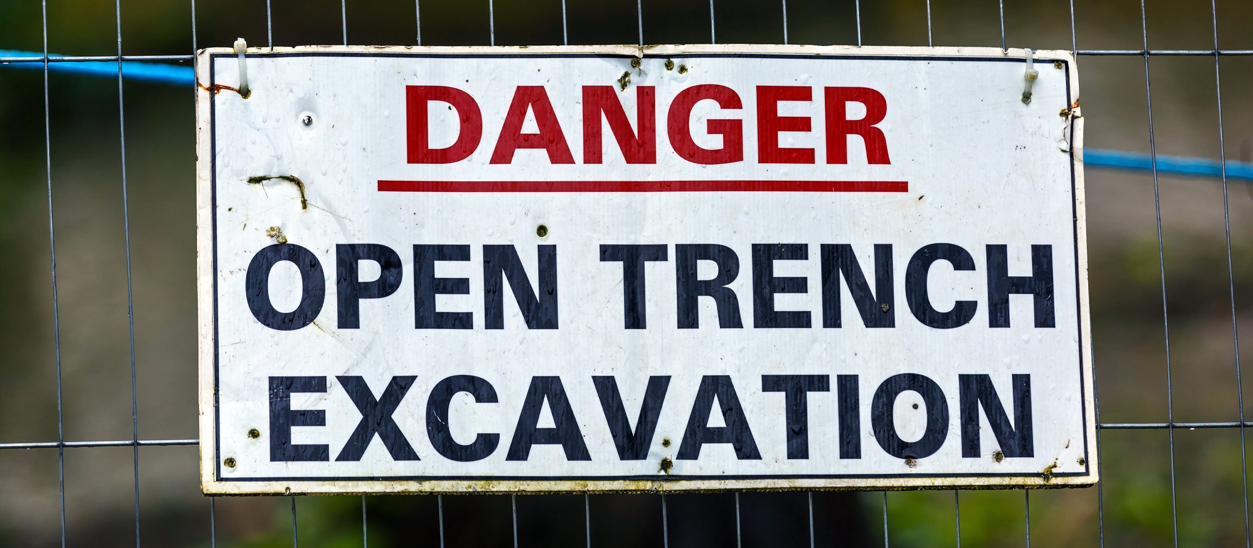 A sign warning of danger due to open trench excavation