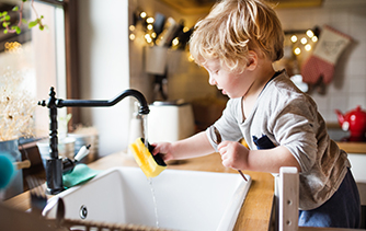 Toddler washing dishes