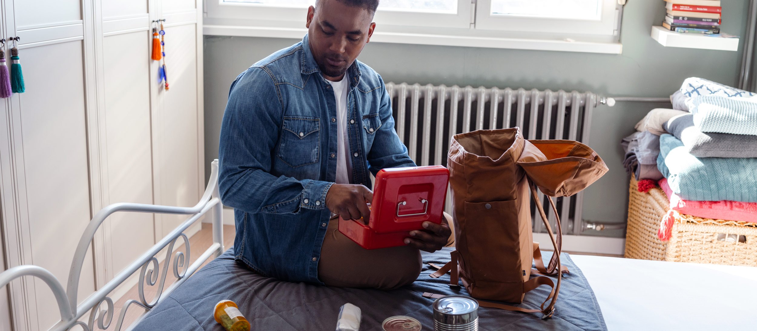 A young man on the phone reviewing his emergency supplies