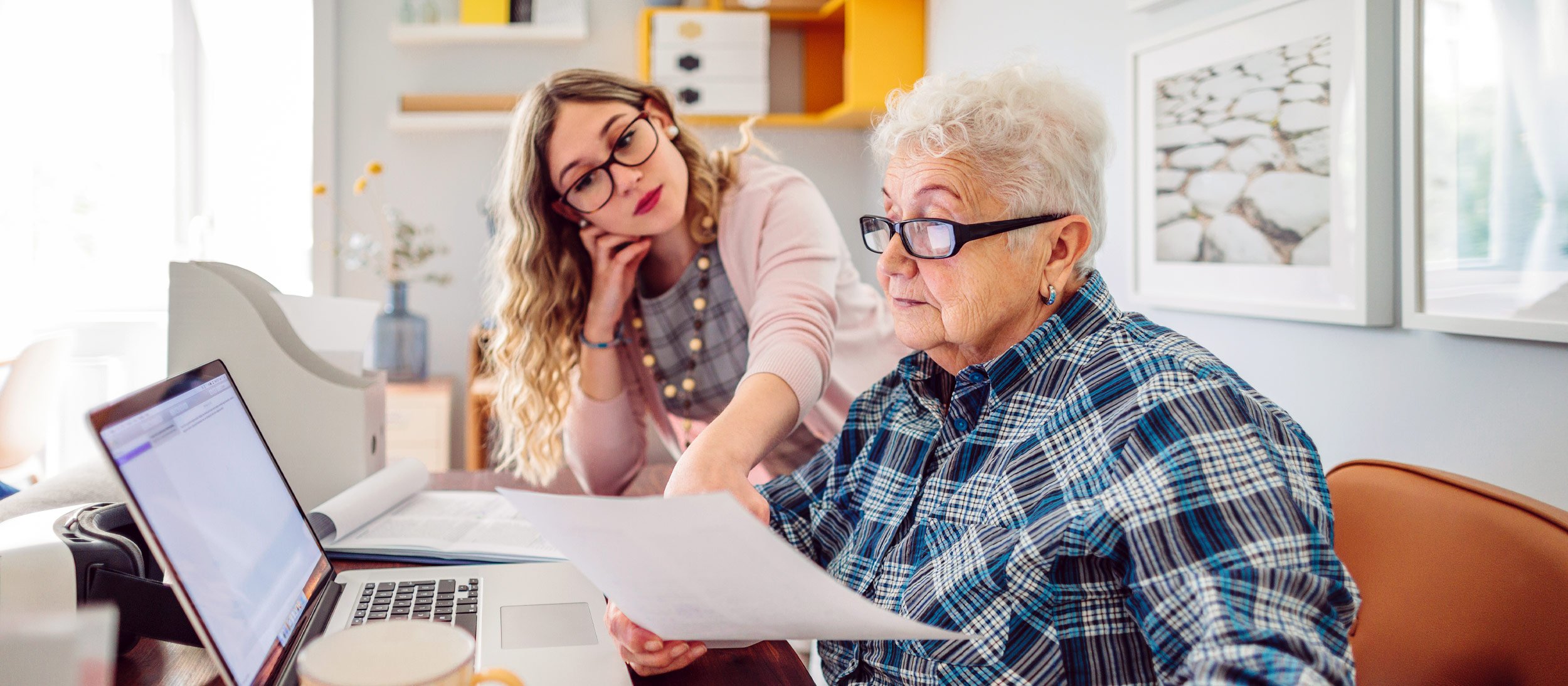 Daughter helping her mother look through paperwork