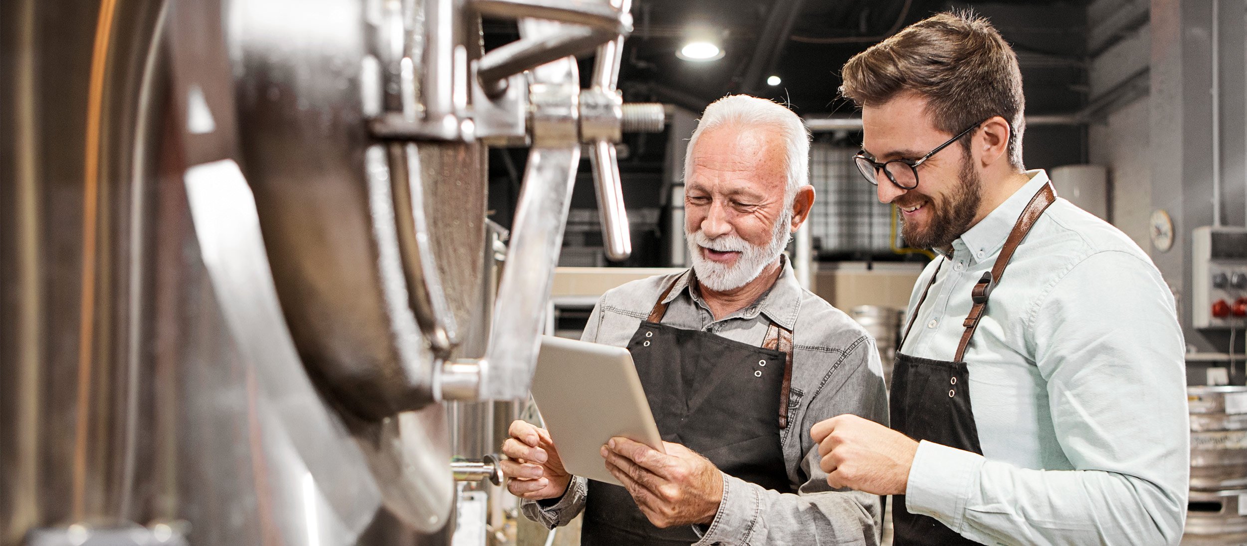 Two men reviewing brewery equipment
