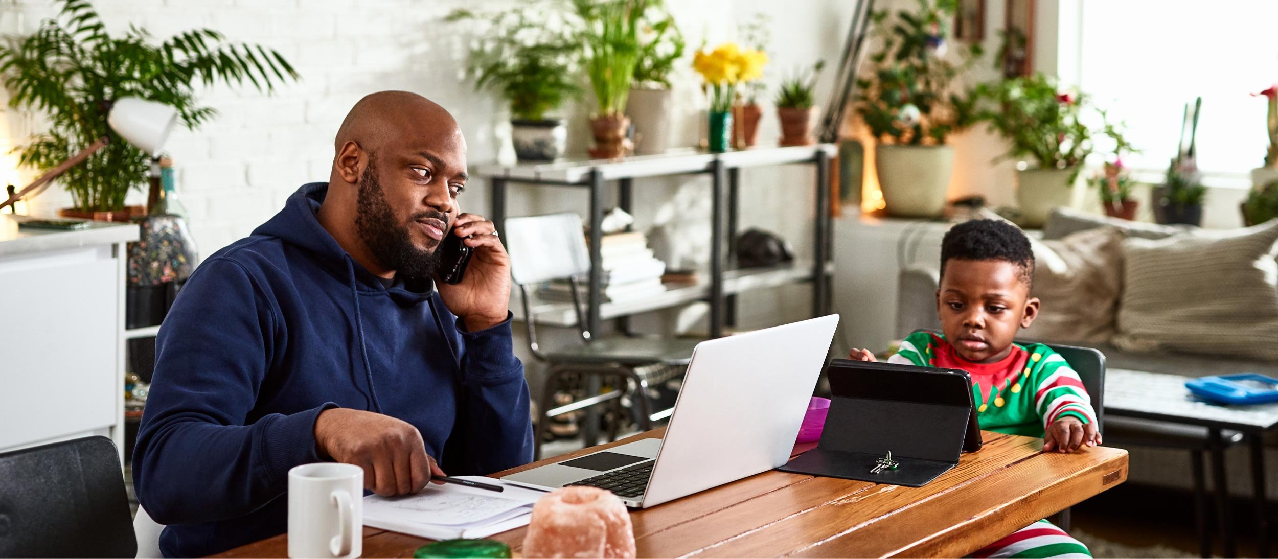 Father working at the kitchen table with his son