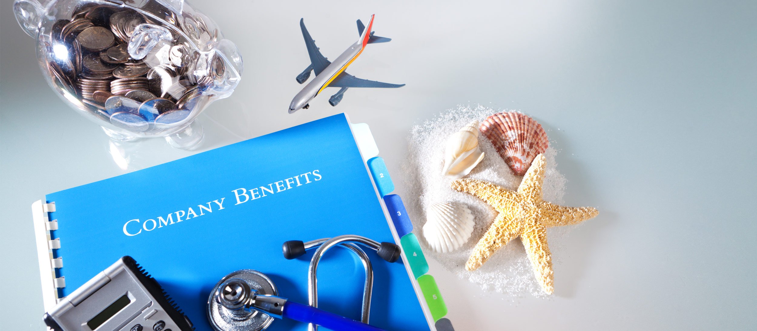 Benefits package with a bank, calculator, shells, travel & stethoscope