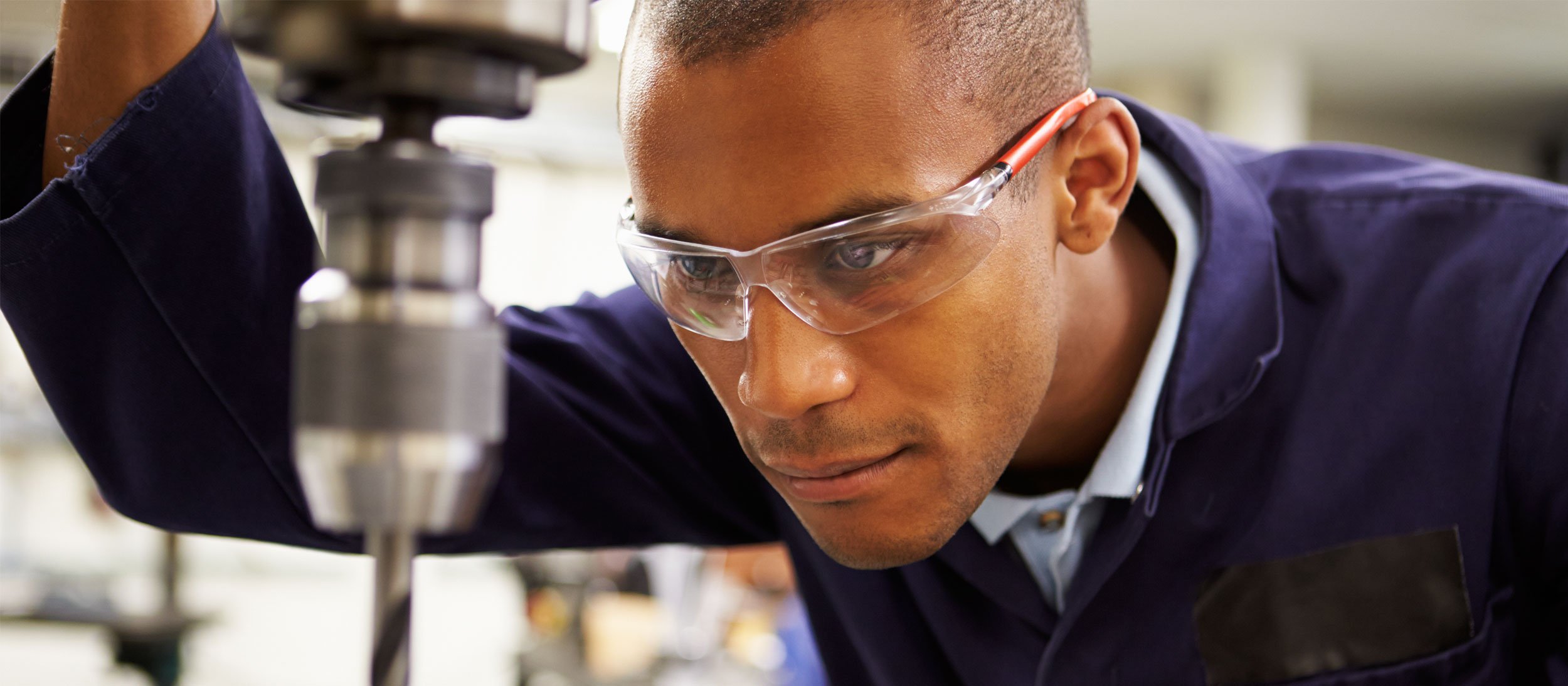 Employee using a drill press