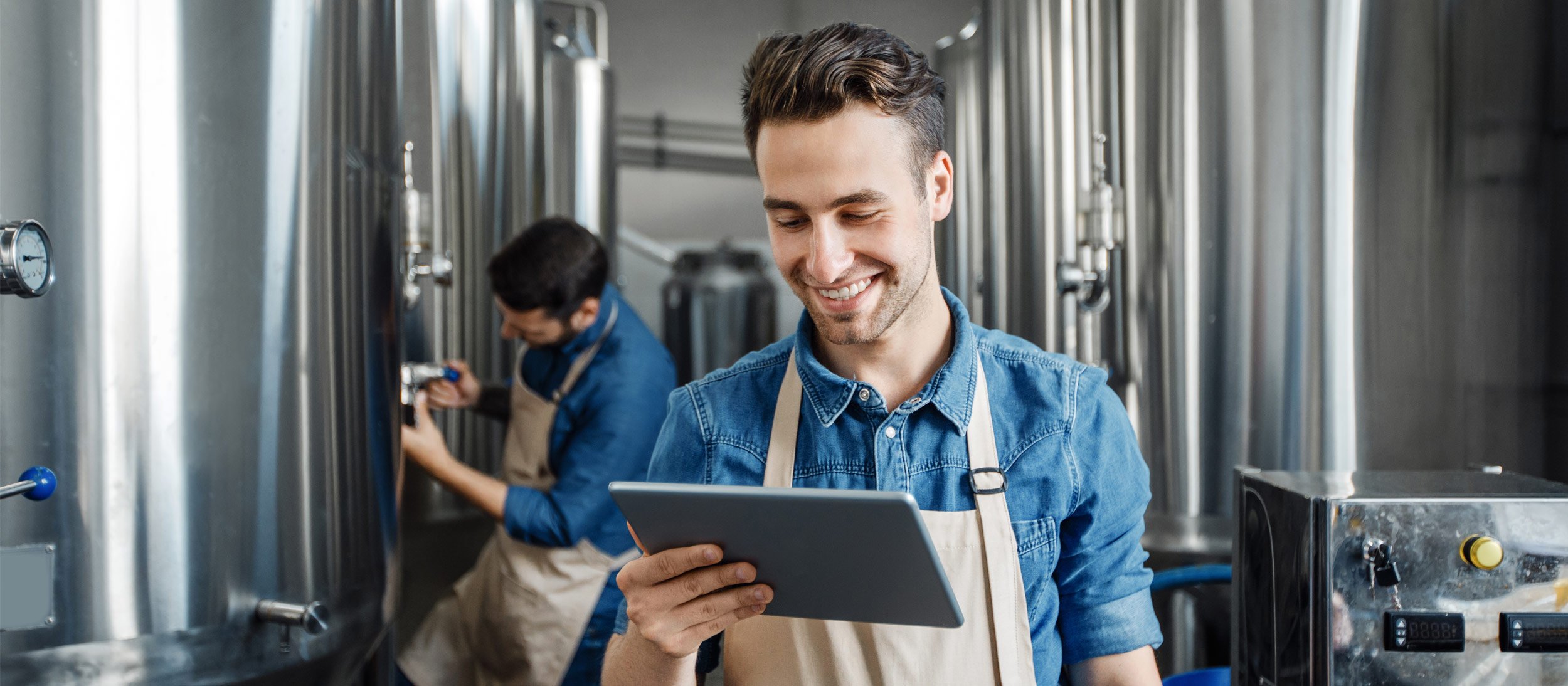 Employee smiling while reviewing the status of the brewery