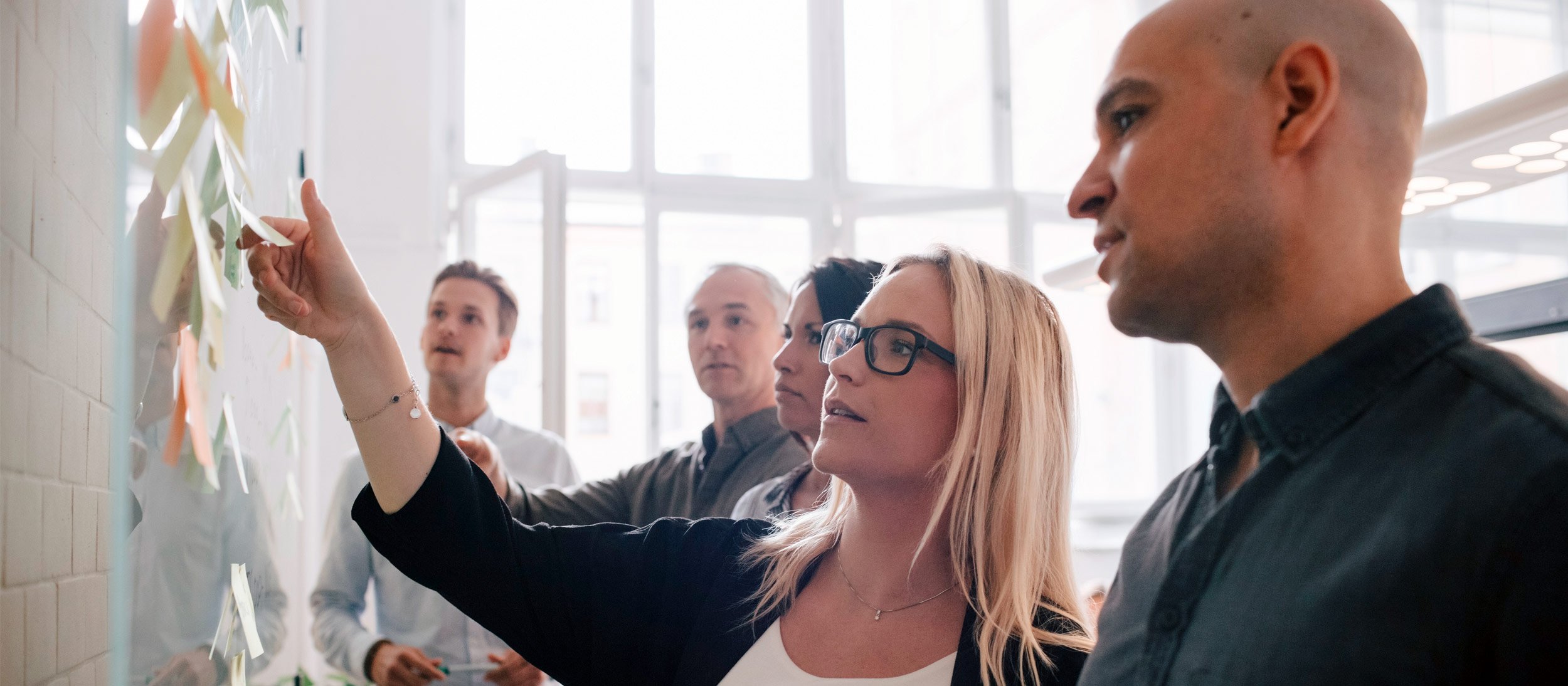 Coworkers discussing an idea board