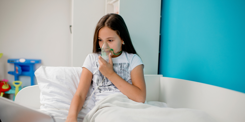 girl using nebulizer for breathing treatment