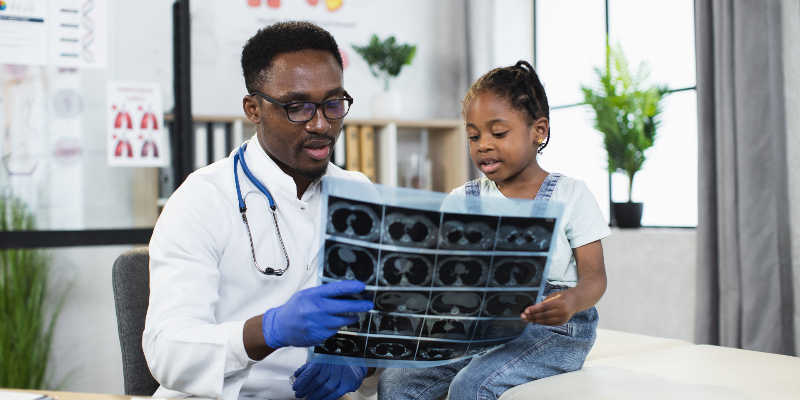 doctor examines xray results with little girl