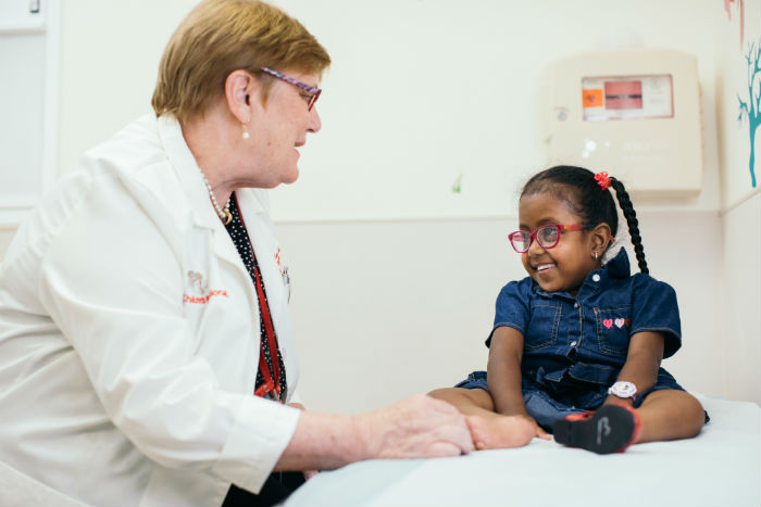 Doctor with little girl on hospital bed