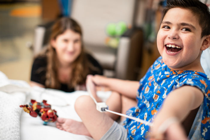 Boy smiling with nurse in the background