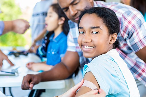 teenager getting a Band-Aid on bicep