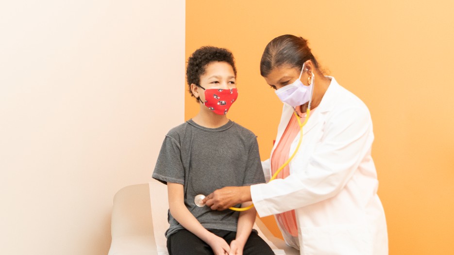 Provider checking the breathing of a teenage patient