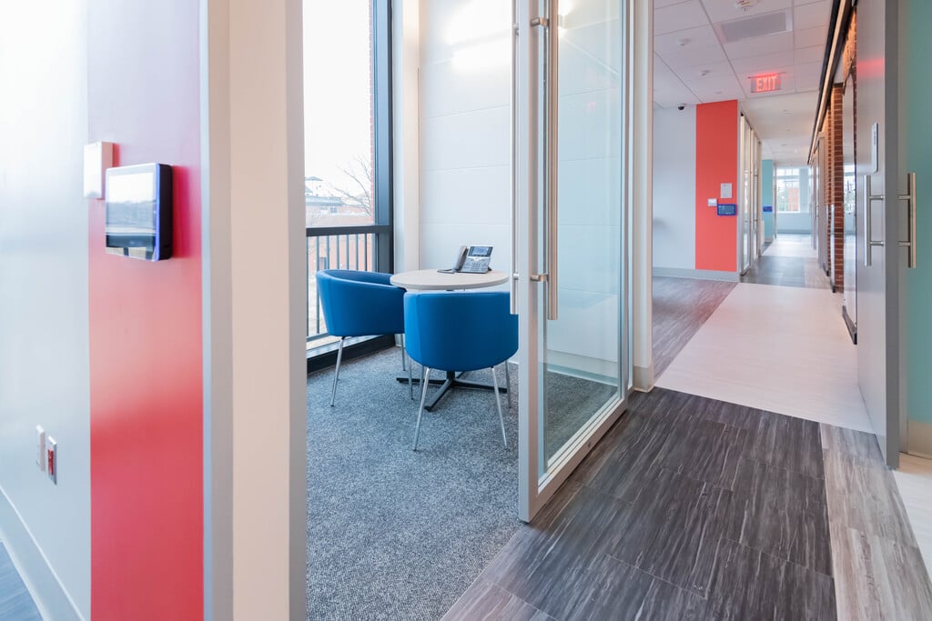 A small table and chairs inside a consultation room near a hallway at the Rare Disease Institute.