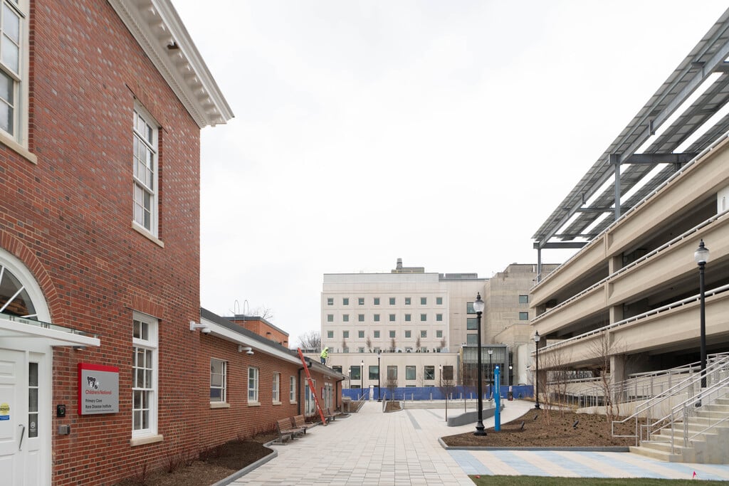 A paved walkway area between the parking garage and main entrance.