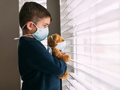 young boy and his teddy bear wearing face masks