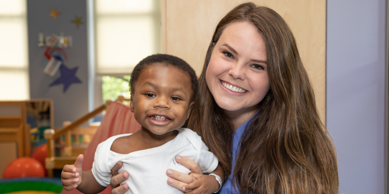 woman holding smiling toddler