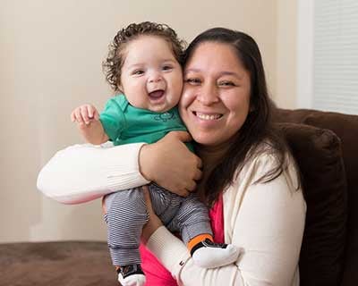 Woman hugging a laughing toddler