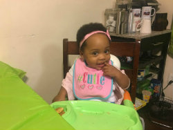 Amarie eats a snack in high chair